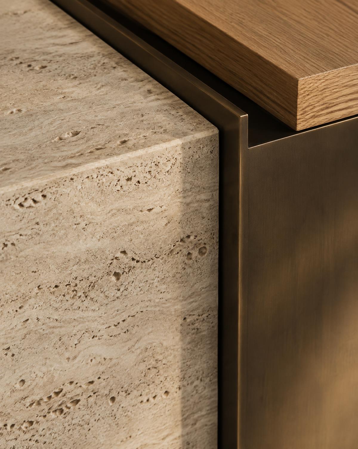 Detail of travertine stone meeting bronze metal and oak